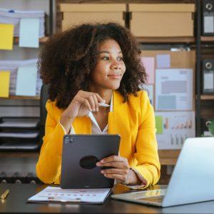 business woman holding an ipad and e-pen in contemplation.
