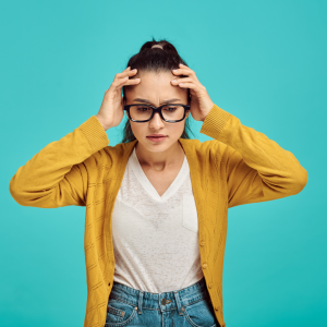 person holding their head with a stressed out look on their face.