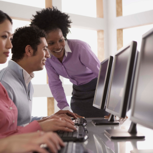 A staff member helping a user at a bank of public computers. 
